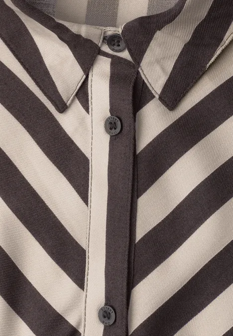 Nahe Ansicht einer schwarz-weiß gestreiften Bluse mit Knopfleiste und Kragen.