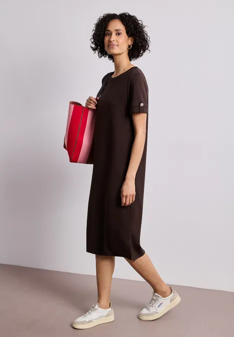 Midi-Kleid mit Rundhals und Knöpfen espresso brown Frau im lockeren dunkelbraunen Midikleid trägt weiße Sneaker und eine rote Tasche vor schlichtem Hintergrund.