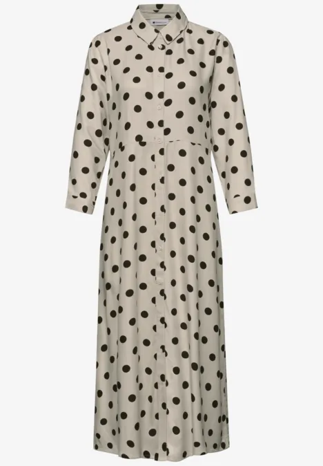 Beige midijurk met overhemdkraag, lange mouwen en zwarte stippen.