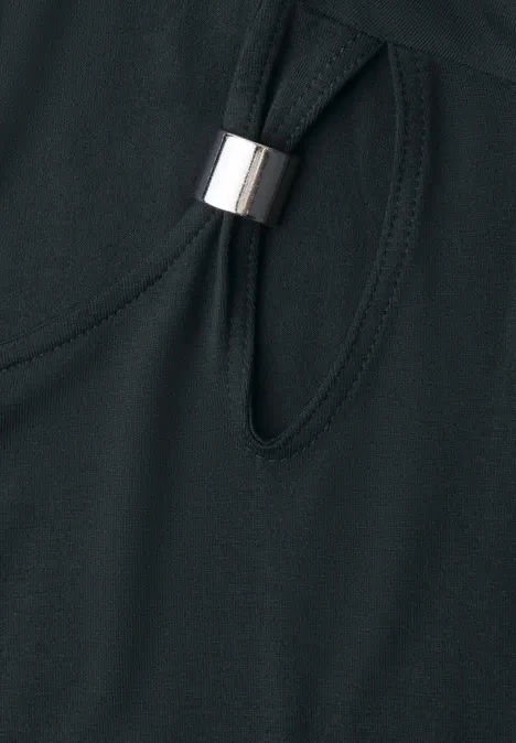 Gros plan sur un tissu noir avec une découpe ovale et un anneau métallique argenté.