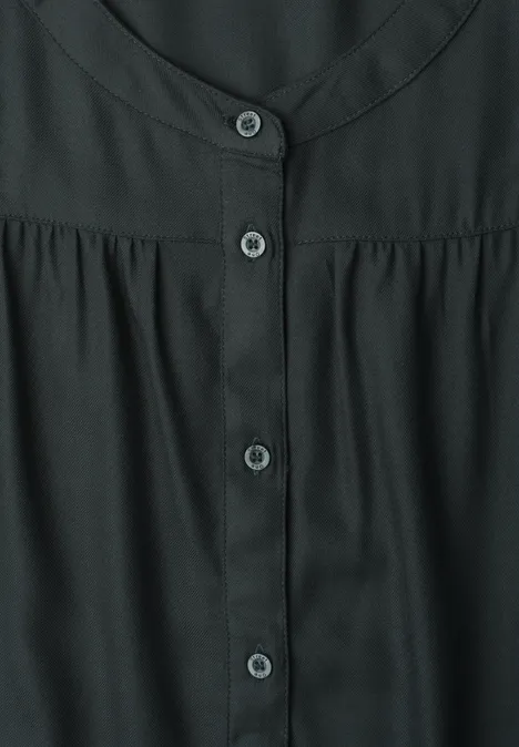 Schwarze Bluse mit rundem Ausschnitt und durchgehender Knopfleiste vorne.