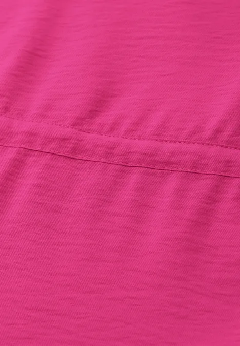 Nahaufnahme eines pinkfarbenen Stoffes mit sichtbarer horizontaler Naht.