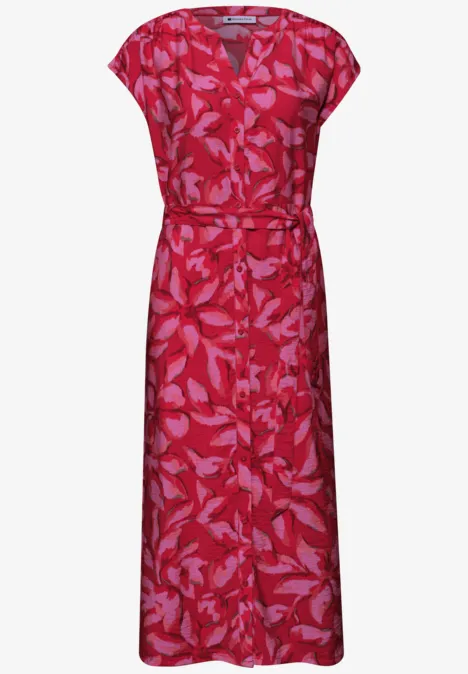 Rode midi-jurk met roze bladprint, korte mouwen en tailleriem.