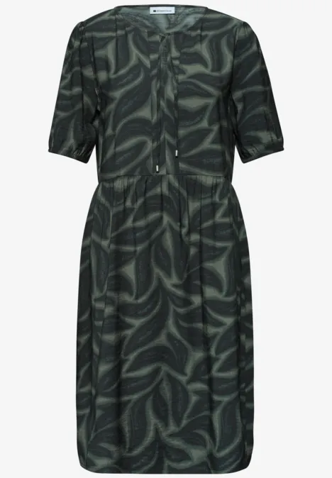 Dunkelgrünes knielanges Kleid mit abstraktem Blattmuster und kurzen Ärmeln.