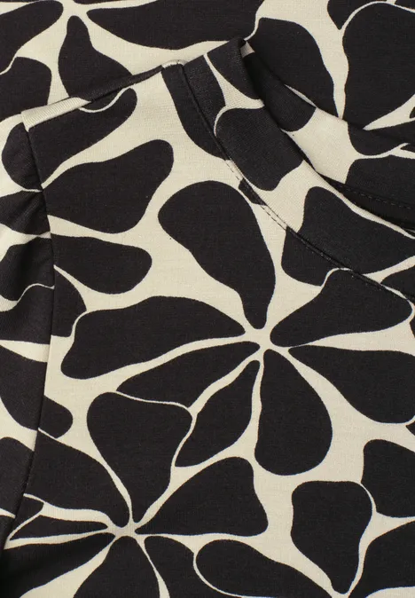 Abstraktes Blumenmuster mit schwarzen, organisch geformten Blüten auf cremefarbenem Stoff