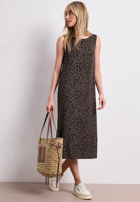 Robe midi en jersey imprimé léopard molten earth Femme en robe midi sans manches à imprimé léopard, baskets blanches et sac en paille tressée.