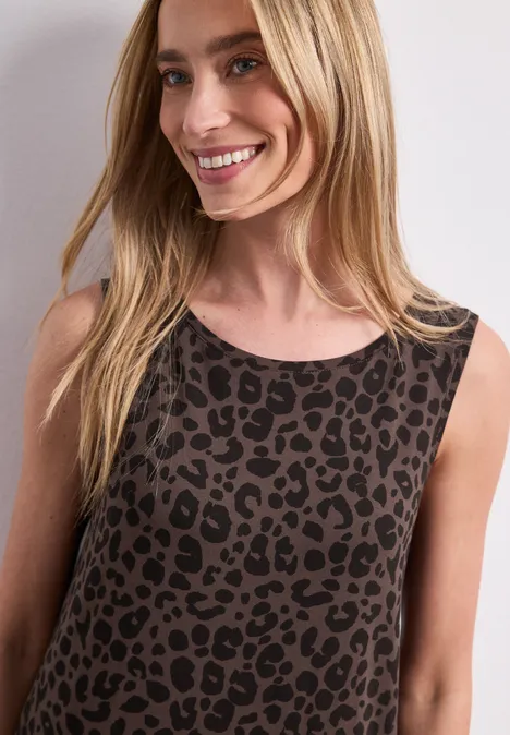 Robe midi en jersey imprimé léopard molten earth Une femme blonde souriante porte un débardeur à imprimé léopard.