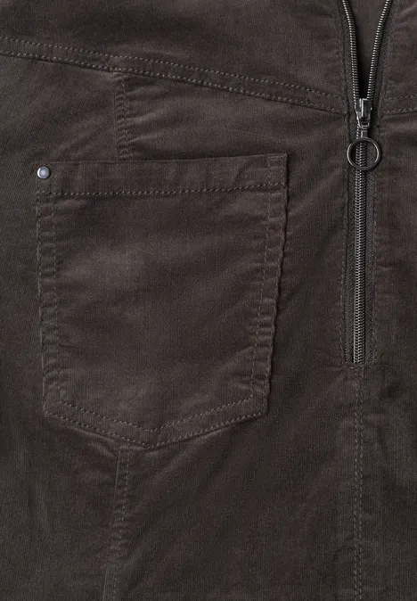 Nahaufnahme einer dunkelbraunen Velourslederjacke mit Reißverschluss und aufgesetzter Tasche.