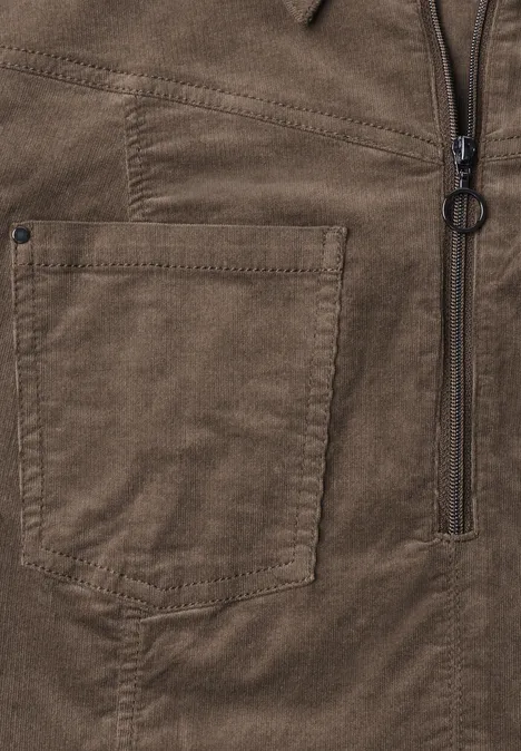 Brauner Cord-/Wildlederstoff mit aufgesetzter Tasche und Reißverschluss mit Ringgriff.
