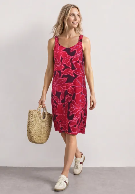 Robe mi-longue à bretelles froncées salsa red Femme en robe rouge sans manches à motif floral imposant, tenue avec un sac en paille et des baskets blanches