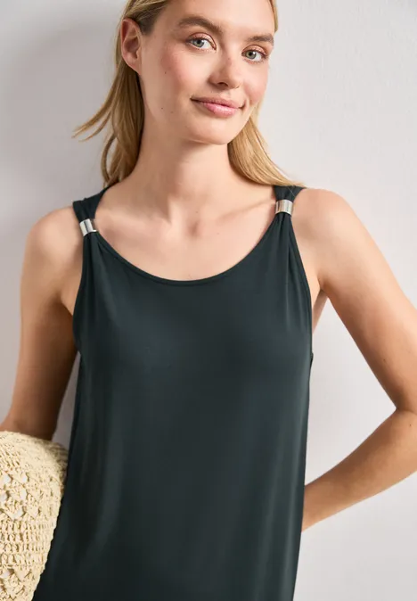 Knielanges Kleid mit Schnallendetail deep bound green Eine Frau trägt ein ärmelloses schwarzes Top mit schmalen Trägern und hält einen Strohhut.