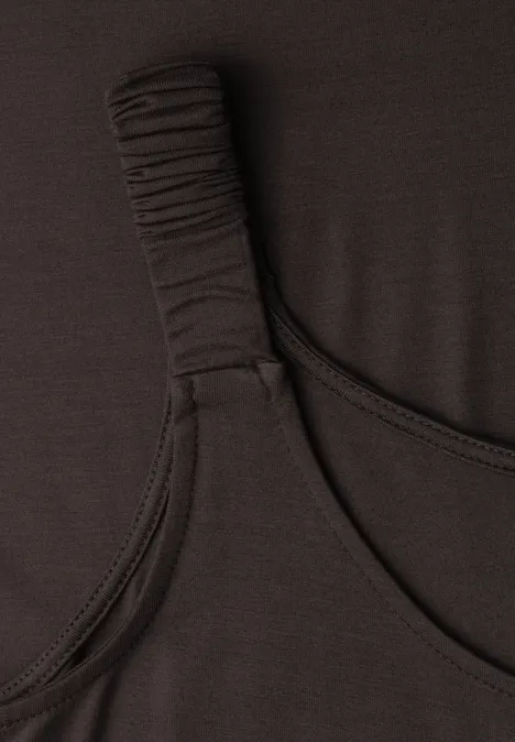 Detailaufnahme eines schwarzen Oberteils mit gerafftem Träger aus elastischem Stoff.