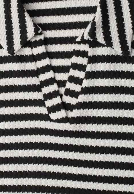 Pull en maille épaisse noir et blanc à rayures, col et décolleté en V.