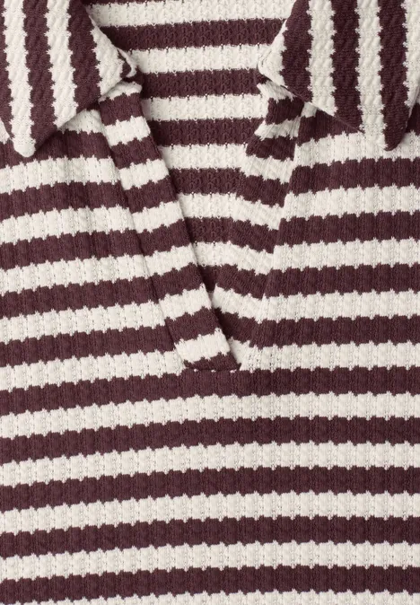 Gros plan d'un polo en maille bordeaux et blanc à col et encolure en V.