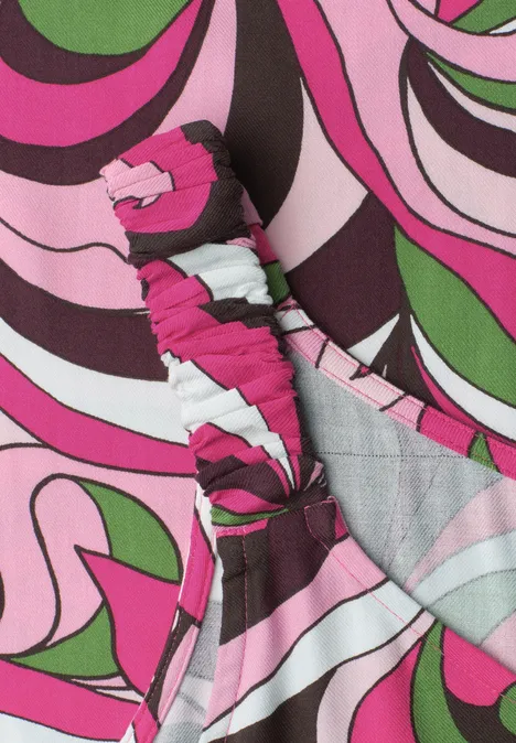 Ein Haarband aus Stoff mit psychedelischem Muster in Pink, Grün, Schwarz und Weiß.