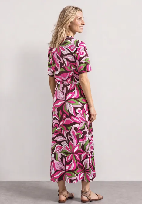 Midi-Kleid mit V-Neck und Print magenta dream Eine Person in einem bunten, floralen Maxikleid steht in Sandalen rückwärts.