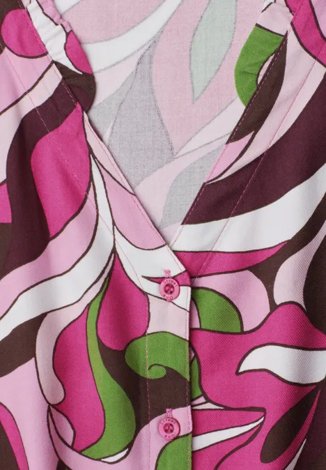 Midi-Kleid mit V-Neck und Print magenta dream Nahaufnahme einer bunt gemusterten Bluse in Pink, Weiß, Braun und Grün mit V-Ausschnitt und pinken Knöpfen.