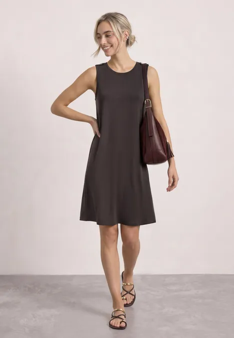 Knielanges Kleid mit Rundhals und Knopfdetail black coffee Eine Frau in ärmellosem schwarzem Kleid, Sandalen und Schultertasche steht locker.