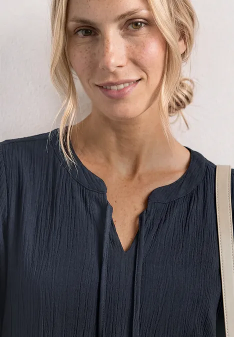Knielanges Kleid mit Schleifendetail darkest blue Frau in dunkelblauer Bluse mit V-Ausschnitt, blonde Haare zu lockerem Dutt gebunden.