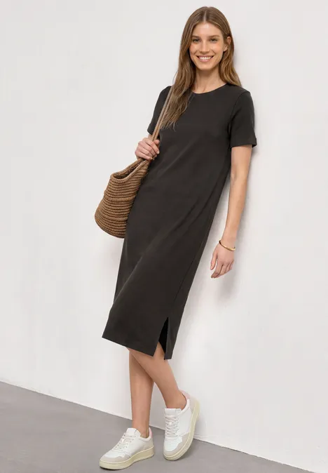 Midikleid in Rippstruktur mit Rundhals black coffee Frau trägt schlichtes schwarzes Midikleid mit kurzem Arm, Seitenschlitz, weiße Sneaker und Korbtasche.