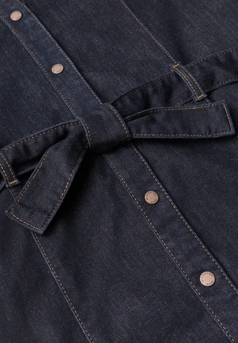 Knielanges Denim Kleid mit Gürtel Rinse Soft Wash Dunkelblaue Jeansjacke mit silbernen Druckknöpfen und Taillengürtel.