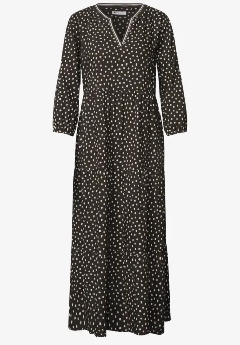 Schwarz-weiß gepunktetes Maxikleid mit V-Ausschnitt, langen Ärmeln und lockerem Fall.