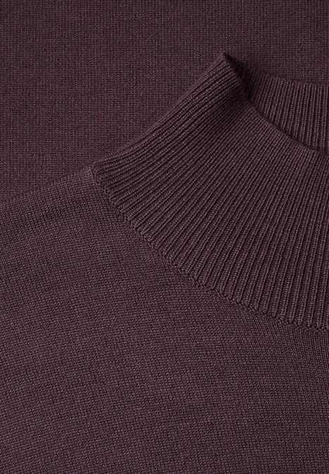 Gros plan d'un pull à col roulé tricoté de couleur violet foncé.