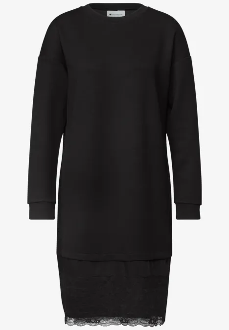 Robe pull noire à manches longues avec bord en dentelle discrète.