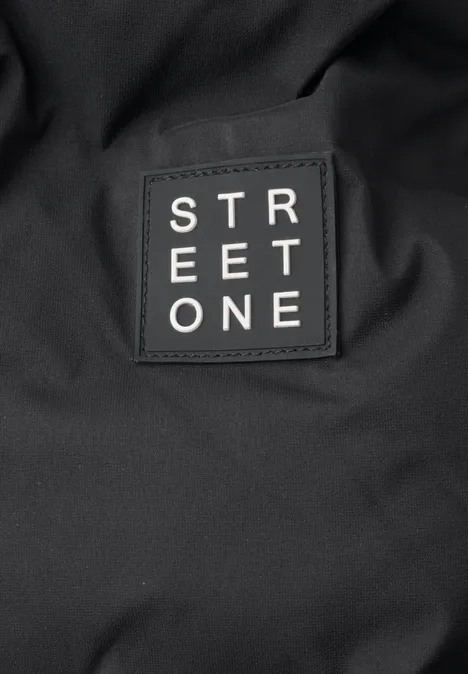 Nahaufnahme eines schwarzen Stoffes mit einem aufgenähten Patch mit der Aufschrift 'STREET ONE'.