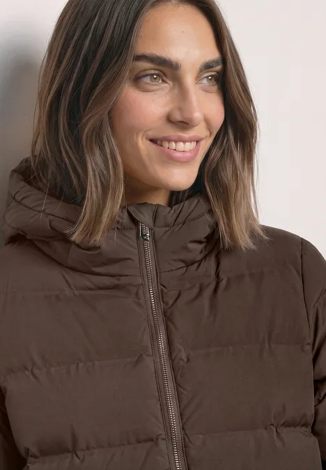 Kurze Jacke mit geklebter Steppung auburn brown Nahaufnahme einer lächelnden Frau in brauner Steppjacke mit Kapuze.
