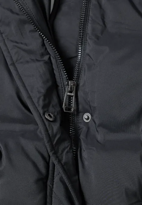 Detailaufnahme einer schwarzen Jacke mit Reißverschluss und Druckknöpfen.