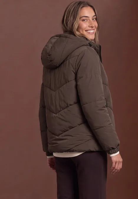 Puffer Jacke mit Teddyfutter in der Kapuze auburn brown Eine Frau trägt eine braune Steppjacke mit Kapuze und lächelt über die Schulter.