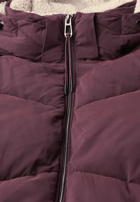 Nahaufnahme einer auberginefarbenen Daunenjacke mit mittigem Reißverschluss und weichem Fleecefutter.