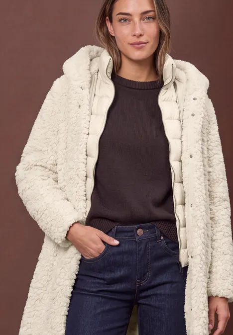 Teddymantel mit gefüttertem Inlay smooth stone sand Frau in dunklem Pullover und Jeans mit cremefarbener, flauschiger Wattierung und Kapuze