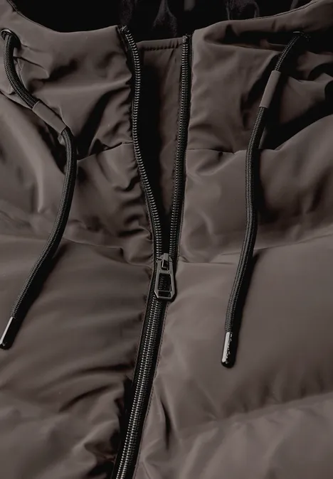 Gros plan d’une veste matelassée avec fermeture éclair et cordon