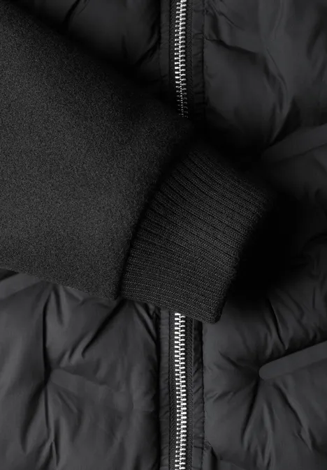 Schwarze, gesteppte Jacke mit Reißverschluss und elastischem Rippbündchen am Ärmel.