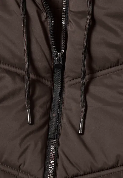 Nahaufnahme einer braunen wattierten Jacke mit Reißverschluss und schwarzen Kordeln mit Metallenden.