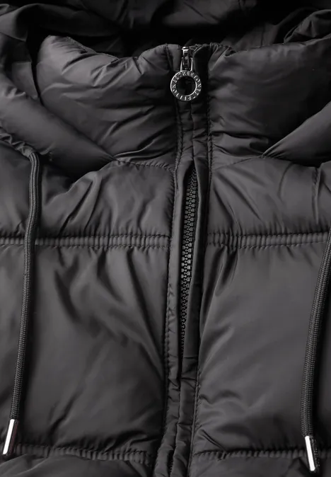 Schwarze Steppjacke mit zentralem Reißverschluss und rundem Zipper-Anhänger.