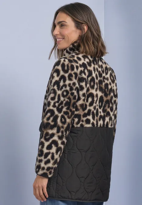 Frau im Rückenblick mit modischer Jacke: Leopardmuster oben, gesteppte schwarze Unterseite.