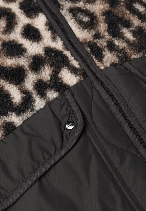 Nahaufnahme einer Jacke mit Leopardenmuster-Fellbesatz, schwarzem Gewebe, Reißverschluss und Druckknopftasche.