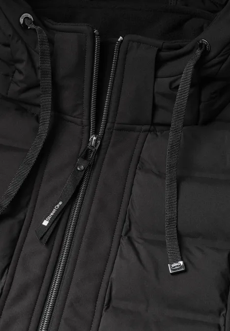 Nahaufnahme einer schwarzen Steppjacke mit Kapuze und Reißverschluss.