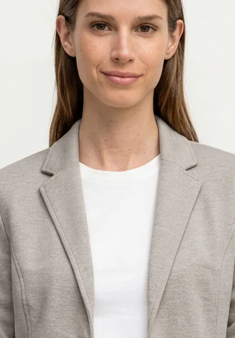 Basic Piqué Blazer clay sand Oberkörper einer Person in beigefarbenem Blazer und weißem T-Shirt, Gesicht unscharf.