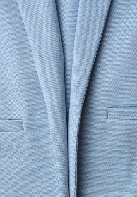 Nahaufnahme eines hellblauen Blazers mit Revers und aufgesetzten Taschen.