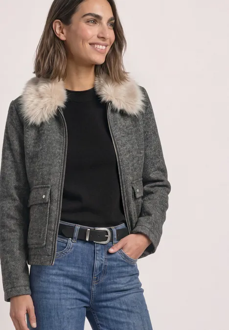 Overshirt mit Woll-Anteil und Fake-Fur-Kragen Obsidian Blue Frau trägt graue Wolljacke mit Fellkragen, schwarzen Pullover, Jeans und Gürtel, lächelnd mit Hand in Tasche.
