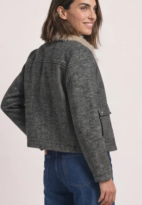 Overshirt mit Woll-Anteil und Fake-Fur-Kragen Obsidian Blue Frau in grauer, kurzer Jacke mit Teddykragen und Jeans, seitlich von hinten fotografiert.