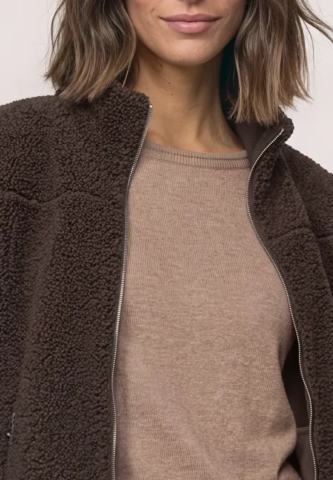 Teddy-Jacke mit Stehkragen und Zipper auburn brown Eine Person trägt eine braune Teddy-Fleecejacke über einem hellbraunen Shirt.