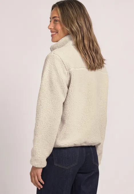 Teddy-Jacke mit Stehkragen und Zipper Soft Fawn Beige Frau trägt hellbeige Teddy-Fleecejacke mit halbem Reißverschluss und blickt über die Schulter.