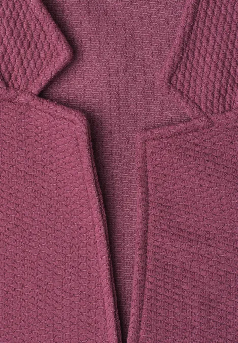 Gros plan d’un vêtement tricoté texturé violet avec revers.