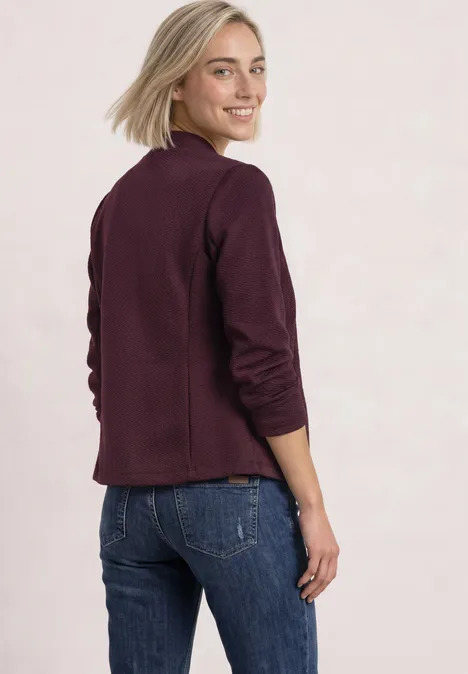 Blazer mit Reverskragen und Struktur rustic rouge Frau mit blondem Haar in burgunderrotem Blazer und Jeans schaut über ihre Schulter.