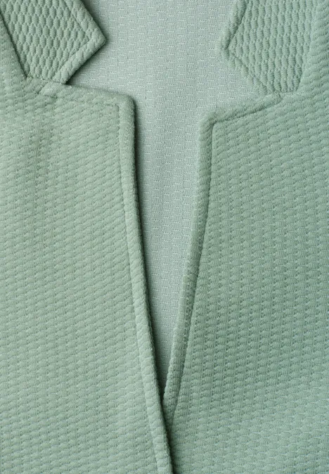 Blazer met reverskraag en structuur eucalyptus green Nahaufnahme einer mintgrünen, strukturierten Jacke mit Revers und markantem Schlitz.